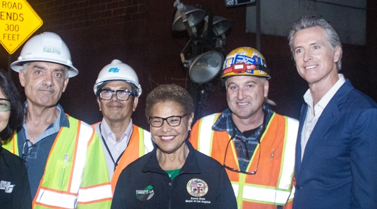 Mayor Bass and Governor Newsom alongside construction workers on the I-10 freeway