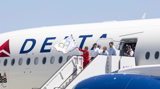 OLYMPIC FLAG LANDS AT LAX