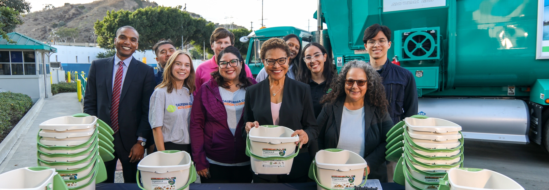 Mayor Bass holding a green pail for composting